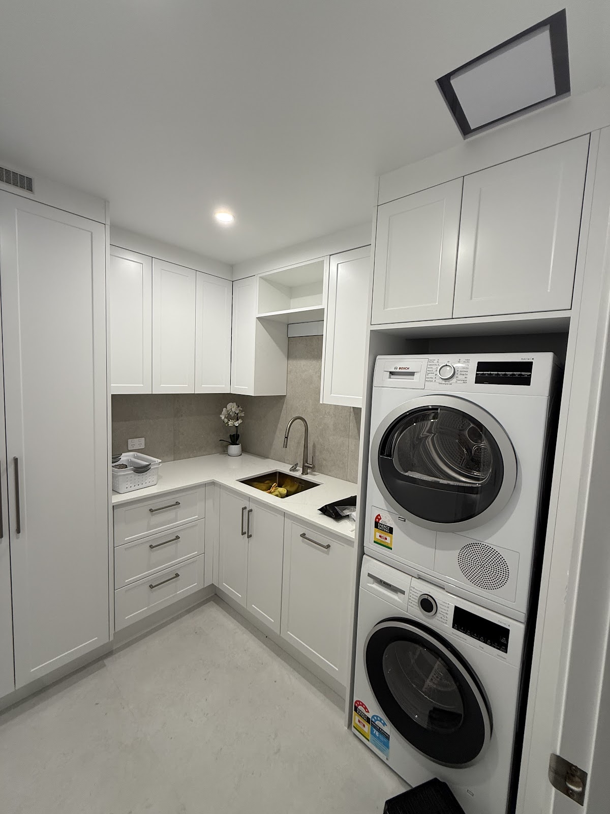 Finished laundry with stacked washer and dryer installation